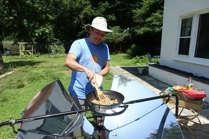 man-cooking-food-on-solar-cooking-device